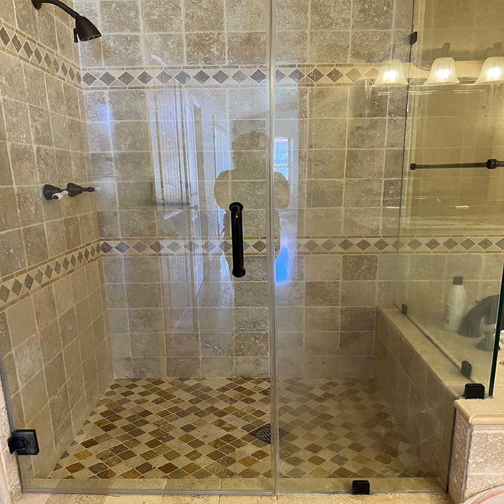 A recently deep-cleaned and sealed shower with spotless glass and tile surfaces in San Pedro, CA, showcasing professional grout sealing and glass polishing.