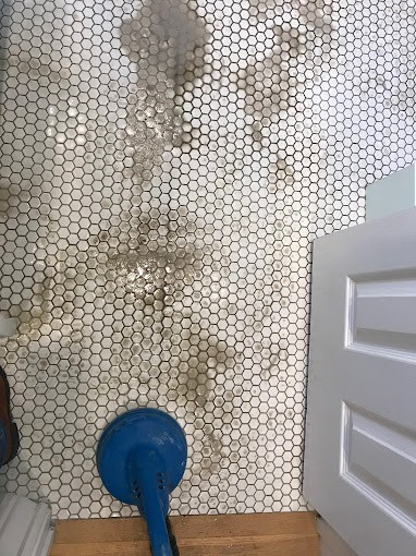 Dirty white hex tile floor with deep grout stains being cleaned professionally in a San Pedro bathroom