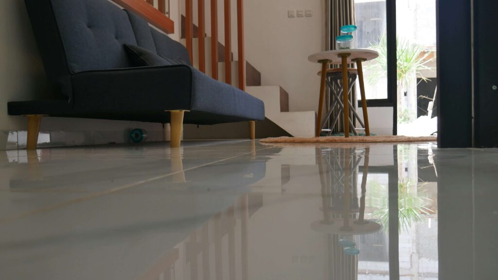 Shiny granite floor in a modern living room with a couch and side table.