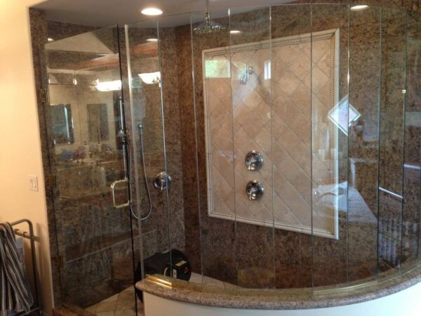 Granite and tile shower with glass doors, part of a Torrance stone vs. tile cleaning guide.