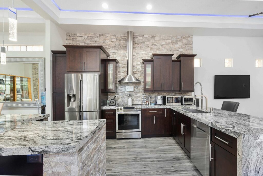 A beautifully restored granite countertop in a modern Manhattan Beach kitchen with dark wood cabinets and stainless steel appliances.