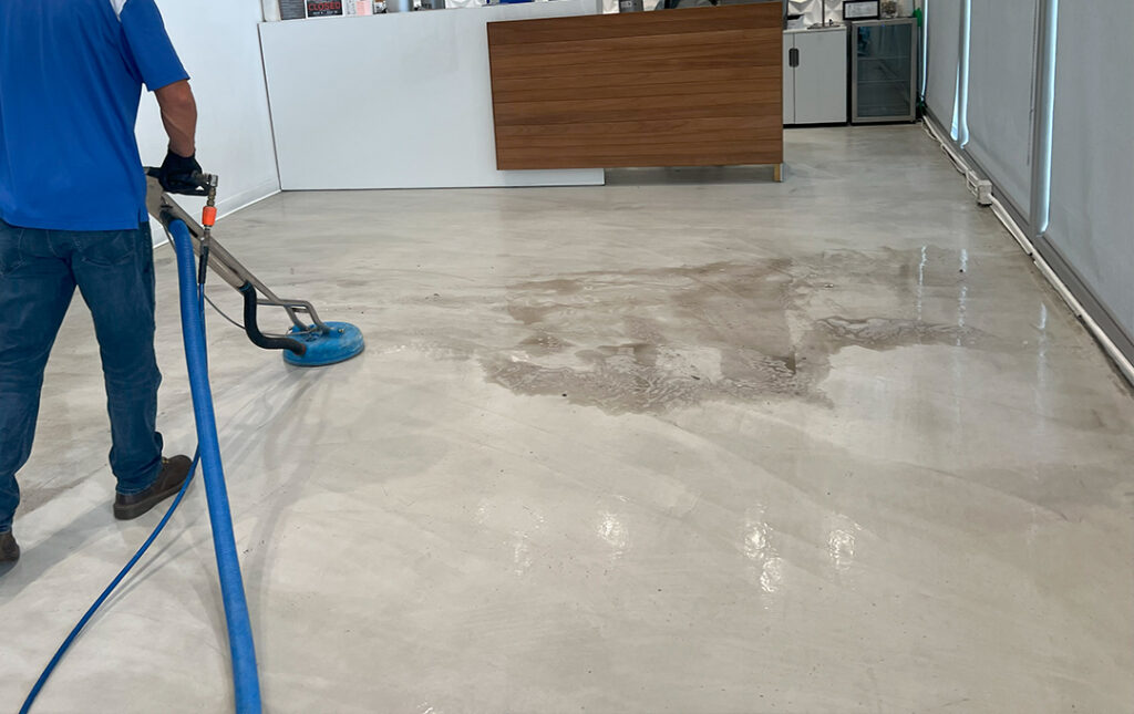 Technician performing water extraction on commercial floor in San Pedro using professional restoration equipment